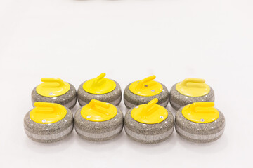 Set of yellow curling stones for one team on an ice rink