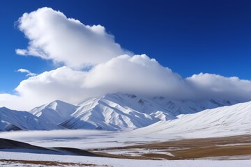 Obraz premium mountains covered in snow and clouds with a blue sky