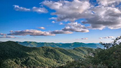 Expansive Mountain range with lush Greenery and Dramatic Clouds