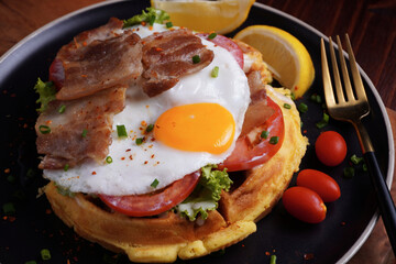 Fried Egg and Pork Waffles Food in a black plate on a wooden table