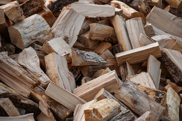 A stack of freshly split firewood, showcasing natural wooden structures and texture. Ideal for heating, camping, woodcraft, or rustic decor purposes.
