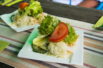 Vegetable mix salad and sour sauce serve with steak on ceramic plate serve dining in restaurant