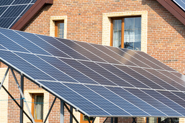 Solar panels on a sloped roof are positioned against a brick house, showcasing the adoption of...