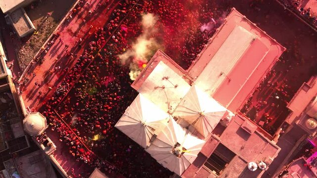Devotees covered in vibrant colors celebrate Holi at Nandgaon temple