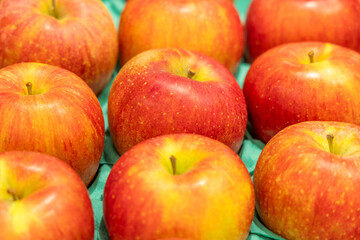 Ripe apples with a rich red and yellow gradient displayed in a fruit market, emphasizing their freshness, organic quality, and appealing appearance