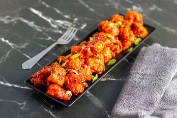 Gobi Manchurian is a crispy, spicy Indo-Chinese dish made with battered, fried cauliflower tossed in a tangy, flavorful soy-garlic sauce.