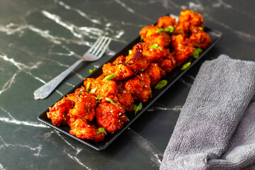 Gobi Manchurian is a crispy, spicy Indo-Chinese dish made with battered, fried cauliflower tossed in a tangy, flavorful soy-garlic sauce.