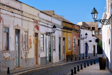 Old town street with weathered cubic houses and beautiful lanterns in Faro, Algarve, Portugal