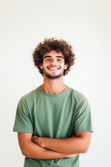 A man with curly hair is smiling and wearing a green shirt