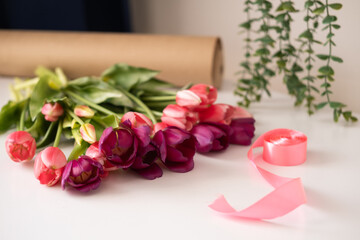 Pink tulips on white background, top view, flat lay with copy space. Spring, flowers concept.
