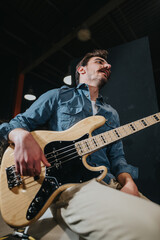 A person performing on a bass guitar, wearing casual clothing, in a studio setting with...
