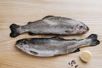 Raw trout fishes on wooden table