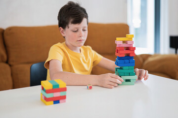 Creative child constructs colorful block towers during playtime at home