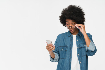 Candid shot of amazed businesswoman with bushy curly hair dressed casually holding her modern...