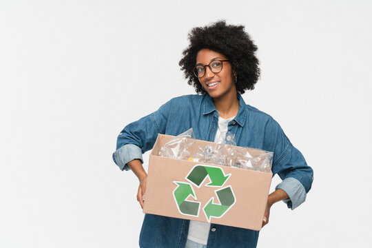 Eco-friendly young african american woman black girl female afro student in casual clothing holding a box full of plastic bottles for recycling isolated over white background. Eco Ecology concept
