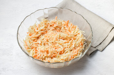 Shredded cabbage and carrot mixture in glass bowl for pancakes or casserole preparation in a glass...