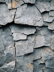Texture of rough gray rock formation displaying cracks
