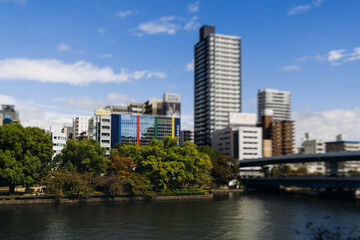 Obraz premium View of Osaka cityscape with Yodo River embankment and skyscrapers, Osaka prefecture, Japan, in a sunny day with a blue sky, streets of Osaka downtown center, travel to Japan