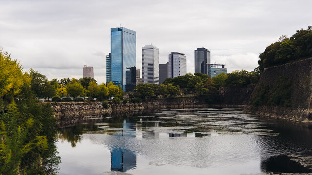 View of Osaka cityscape with Yodo River embankment and skyscrapers, Osaka prefecture, Japan, in a sunny day with a blue sky, streets of Osaka downtown center, travel to Japan