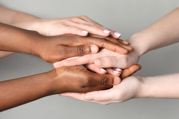 Stop racism. People of different skin colors holding hands on light grey background, closeup