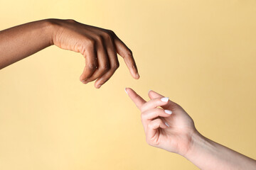 Stop racism. People of different skin colors joining hands on beige background, closeup
