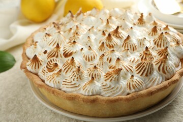 Delicious meringue pie on beige table, closeup