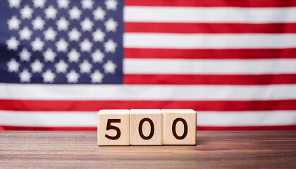Wooden blocks with number 500 on table in front of blurred American flag. The USA. Minimalist design