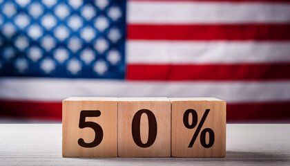 Wooden blocks with number 50 percent on table in front of blurred American flag. The USA.