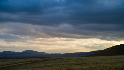 Fototapeta premium sunset in the mountains. The sun is shining through the clouds