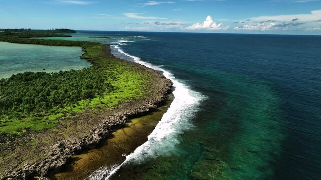 Aerial view of pristine tropical reef and serene waves along the coastline, Goro, South Province, New Caledonia.