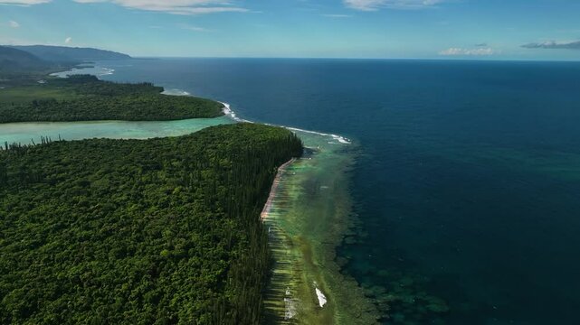 Aerial view of lush green islands and clear blue ocean with coral reef, Goro, South Province, New Caledonia.