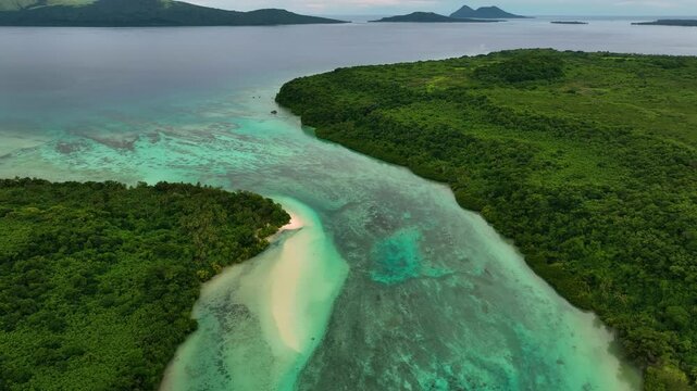 Aerial view of beautiful turquoise lagoon with serene waves and lush palms along the idyllic shoreline, Port Vila, Shefa, Vanuatu.
