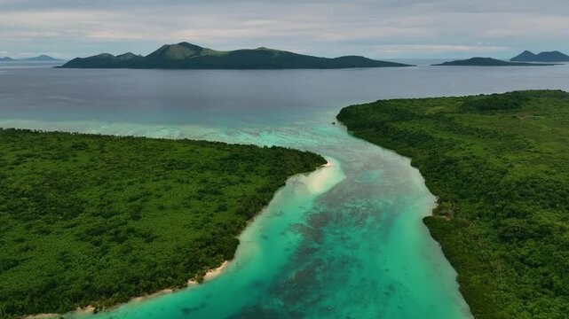 Aerial view of serene tropical beach with lush palms and clear water, Port Vila, Shefa, Vanuatu.
