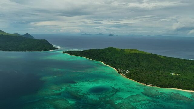 Aerial view of serene beach with turquoise water, waves, and palm trees along the shoreline, Port Vila, Shefa, Vanuatu.