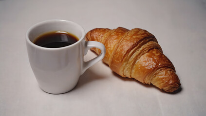 Coffee and croissant on a white tablecloth