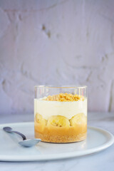 homemade no-bake banoffee pie in a glass cups on white table.
