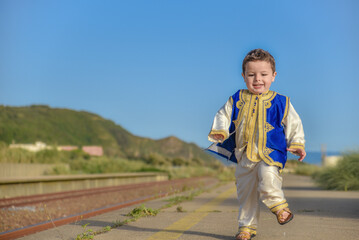 Eid clothes, Happy Muslim child in traditional dress on Eid day, A little boy playing and having...