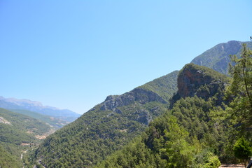 Scenic view of a mountain range with lush green vegetation and a clear blue sky