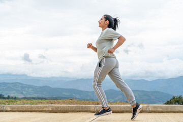 Lifestyle: Athletic Latina woman running on the road