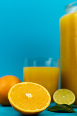 Orange pillows, a glass of orange juice on a blue background. Oranges and juice