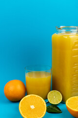 Glass of orange juice in glass close-up. Cut oranges on the table.