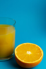 Close-up of freshly cut orange and glass of freshly squeezed juice