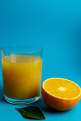 Close-up of freshly cut orange and glass of freshly squeezed juice