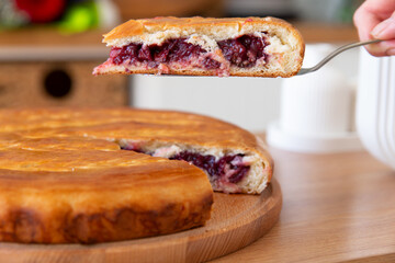 Taking a piece of cherry pie with a spatula.
