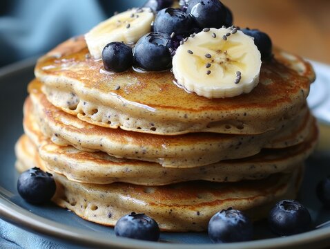 Stack of fluffy pancakes with fresh blueberries banana slices and syrup for delicious breakfast treat