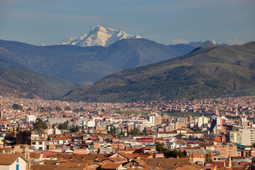 Cusco city, The heart of the Inca Empire, framed by the towering presence of Apu Ausangate, one of the most sacred mountains in the Andes.