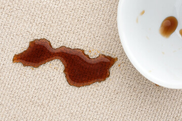 Coffee spill on light fabric surface creates a striking contrast and highlights the need for careful handling.