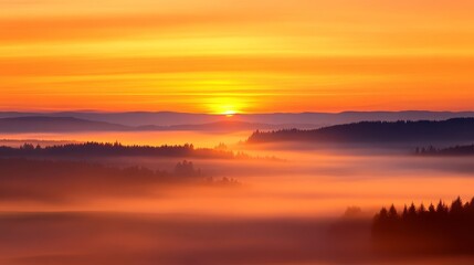 Fototapeta premium Serene sunset over misty hills with vibrant orange hues, reflecting tranquility and nature's beauty
