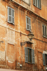Façade d'immeuble ocre à Rome avec lampadaire et fenêtre