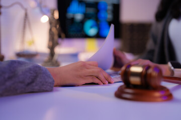 Lawyers are reviewing legal documents with a gavel and statue of Themis, the Greek goddess of justice, visible in the background, symbolizing the importance of law and order